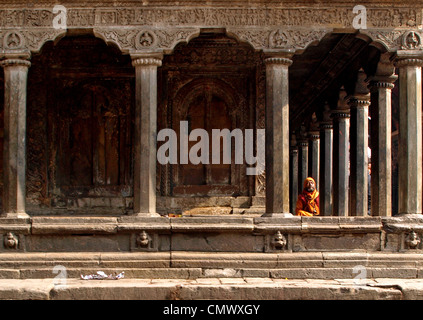 Hindu uomo seduto al di fuori di un tempio di Patan Durbar Square. Foto Stock