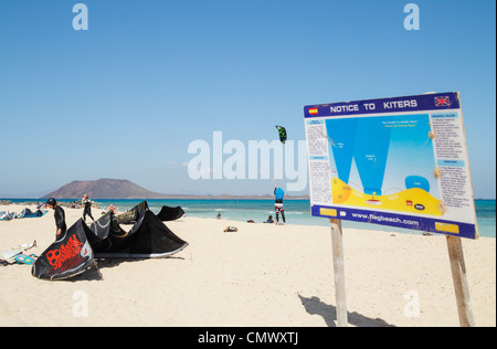 Kitesurfisti sulla bandiera spiaggia vicino a Corralejo con Isola di Lobos in distanza. Fuerteventura Isole Canarie Foto Stock