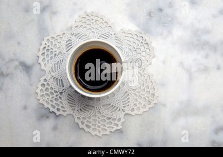 Tazza di caffè nero appoggiato su un centrino. Foto Stock