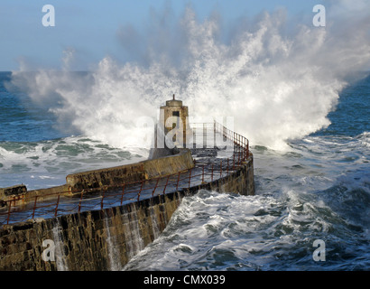 Una grande onda schizzi sul molo Portreath, Cornwall Regno Unito. Foto Stock