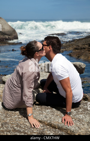 Coppia (Amici) kissing sulle rocce Foto Stock