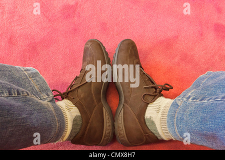 Fotografo della visione del proprio piedi indossando scarpe marrone. Foto Stock