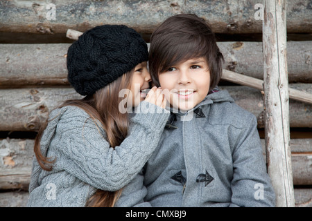 Germania, Huglfing, un ragazzo e una ragazza whispering a ciascun altro Foto Stock