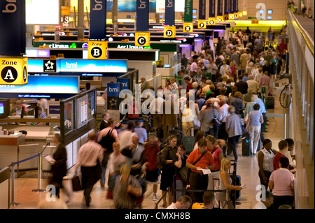 Banchi per il check-in in partenza occupato lounge presso l'aeroporto di Heathrow Foto Stock