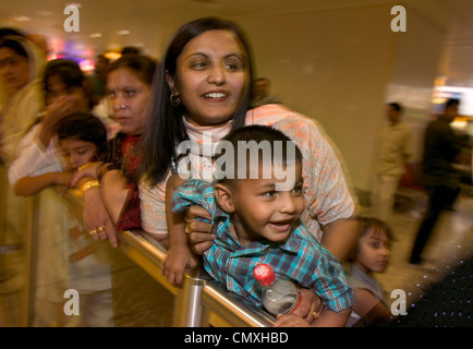 La famiglia in attesa presso il lounge degli arrivi all'aeroporto di Londra Heathrow Foto Stock