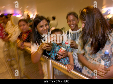 La famiglia in attesa presso il lounge degli arrivi all'aeroporto di Londra Heathrow Foto Stock