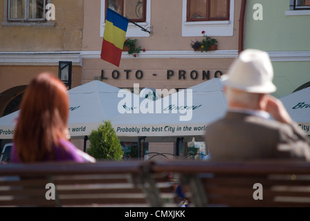 La gente seduta su una panchina nel centro di Brasov Foto Stock
