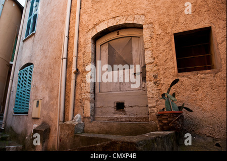 Una immagine di una breve porta in legno per un edificio francese, presa durante il tramonto. Foto Stock