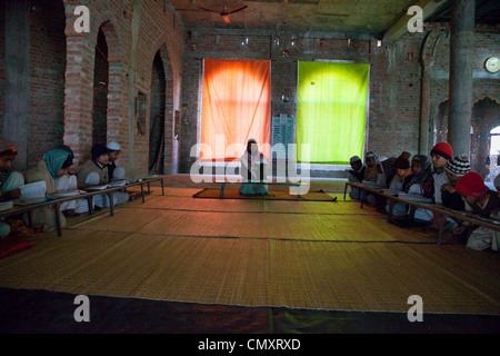 Madrasa gli studenti con i loro imam, all'interno della moschea in costruzione. Madrasa Islamia saudita Izharul-Uloom, Dehradun, India. Foto Stock