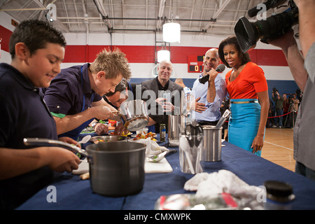 La First Lady Michelle Obama, Sam Kass, politica di Senior Advisor per il cibo sano iniziative e Top Chef capo giudice Tom Colicchio, centro, guarda come chef di passate stagioni di "Top Chef' e agli studenti di prendere parte a un concorso di cucina presso la Kleberg Rylie centro ricreativo Febbraio 10, 2012 a Dallas, T Foto Stock