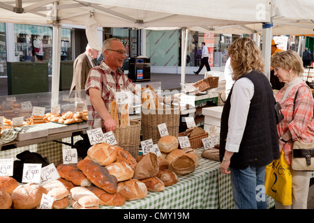 Persone che acquistano il pane in stallo panettieri, Bury St Edmunds Suffolk del mercato UK Foto Stock