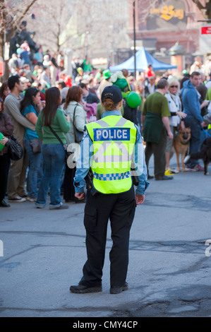 Femmina funzionario di polizia in servizio durante il 2012 il giorno di San Patrizio parade di Montreal, provincia del Québec in Canada. Foto Stock