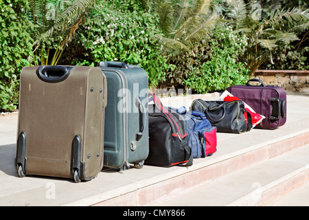 Fila di bagagli imballati sotto il sole dopo il check out Foto Stock