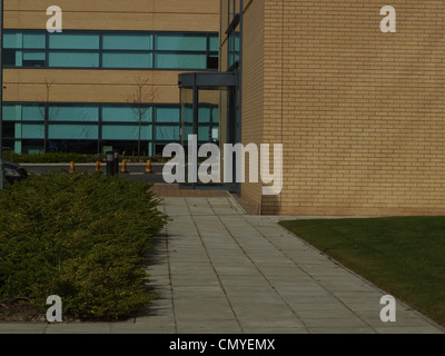 Un passaggio pedonale che porta in un vetro del pannello di edificio commerciale presso la Cobalt Business Park. Foto Stock