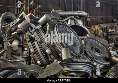 Pila di metallo colato di pezzi in una fonderia di ferro Foto Stock