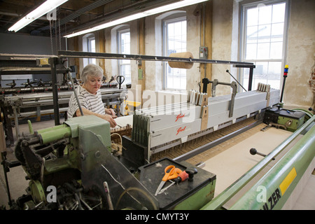 Lavoratore opera un telaio presso la storica Amana Wollen Mill Foto Stock