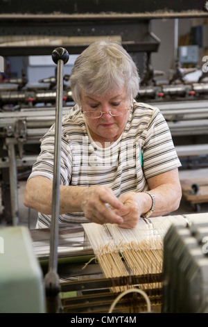 Lavoratore opera un telaio presso la storica Amana Wollen Mill Foto Stock