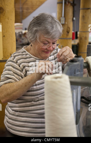Lavoratore opera un telaio presso la storica Amana Wollen Mill Foto Stock