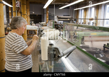 Lavoratore opera un telaio presso la storica Amana Wollen Mill Foto Stock