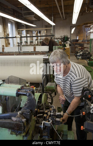 Lavoratore opera un telaio presso la storica Amana Wollen Mill Foto Stock