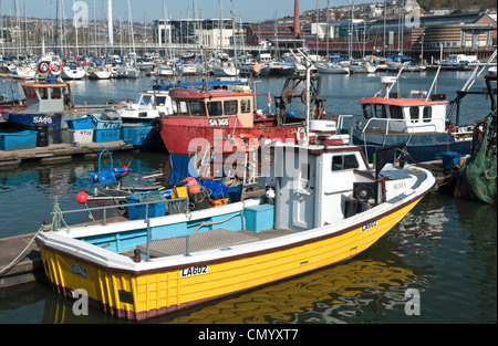 Barche da pesca ormeggiate nel quartiere di pesca di Swansea Marina South Wales con un molto prominenti giallo barca in primo piano. Foto Stock