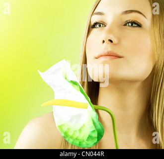 Nuovo volto femminile ritratto, bellissimo modello holding calla fiore, pelle perfetta ragazza verde sullo sfondo a molla, equilibrio zen