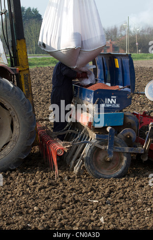 Un agricoltore il rifornimento di un Ransomes Nordsten CLB 4 metro trapano di grano in Southport Foto Stock