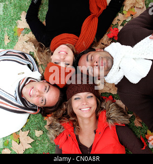 Gruppo di sorridenti giovani adulti in autunno Foto Stock