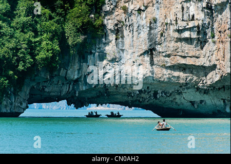 I turisti in barca sotto un arco calcareo, la baia di Ha Long, Halong Bay. UNESCO - Sito Patrimonio dell'umanità. Il Vietnam. Foto Stock