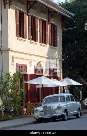 Un classico Mercedez Benz automobile è parcheggiata di fronte 3 Nagas ristorante su una strada di città a Luang Prabang, Laos. Foto Stock