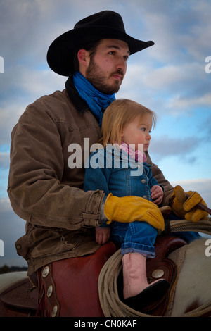 Un cowboy e sua figlia a cavallo al ranch nel nord-est del Wyoming Foto Stock