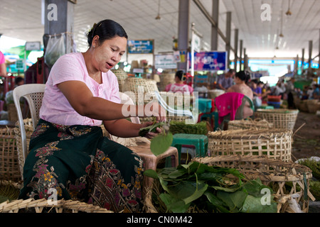 Una donna (indossando 'thanaka') tipi di betel foglie in Thirimingalar prodotti freschi di mercato in Yangon (Rangoon), Myanmar (Birmania) Foto Stock