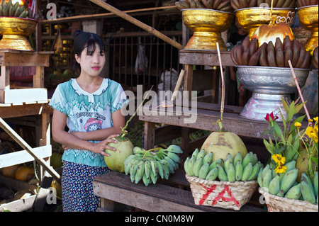 Una ragazza birmani in una bancarella di strada vende golden offerte al di fuori del Botataung Paya a Rangoon, Birmania Foto Stock