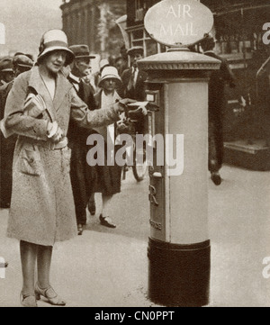 Una donna spedire una lettera in una delle prime Air Mail caselle montante eretta in The Strand, Londra, Inghilterra in 1930. Foto Stock