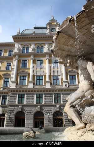 Una fontana con statue di marmo di fronte ad un edificio storico (Trieste, Italia) Foto Stock