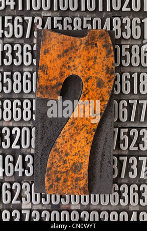 Numero sette in rilievografia vintage tipo legno sullo sfondo casuale di numeri di metallo Foto Stock