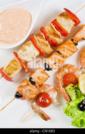 Primo piano di grigliate di salmone e gamberetti con pomodori e peperoni sulle canne di bambù Foto Stock