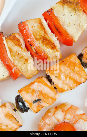 Primo piano di grigliate di salmone e gamberetti con pomodori e peperoni sulle canne di bambù Foto Stock