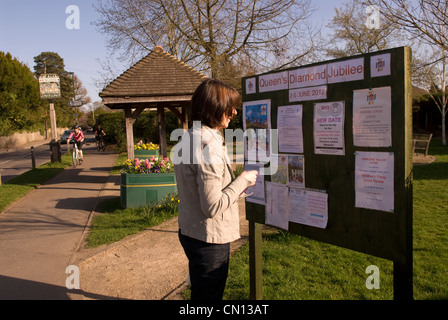 Residente locale persuing bacheca nel villaggio di Rowledge in materia di diamante della regina celebrazioni giubilari nel giugno 2012 Foto Stock