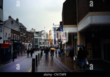 Surrey in Inghilterra Sutton High Street People Shopping sotto la pioggia Foto Stock