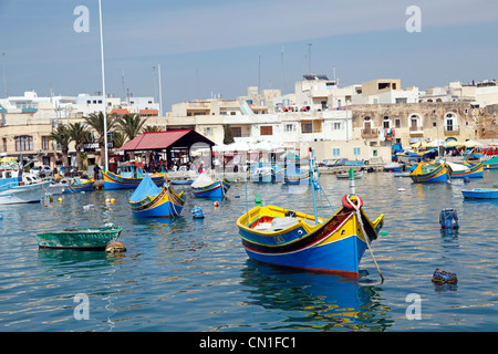 Tradizionali barche da pesca maltesi noto come dghajsa nel porto di Marsaxlokk, Malta Foto Stock