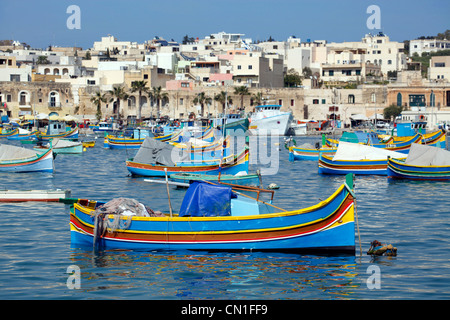 Tradizionali barche da pesca maltesi noto come dghajsa nel porto di Marsaxlokk, Malta Foto Stock