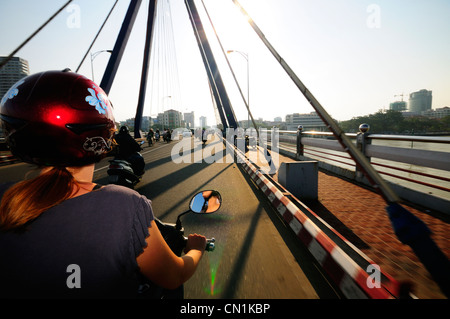 Conducente il punto di vista delle Donne Equitazione moto sopra la canzone Han Ponte nel centro di Da Nang, Vietnam Asia, Foto Stock