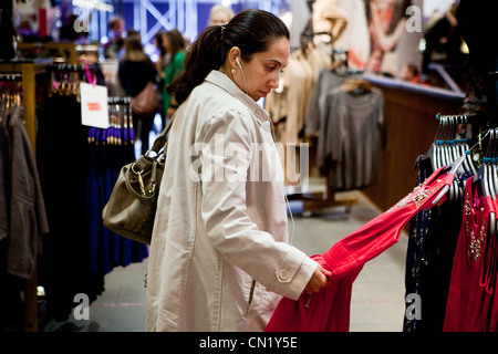 Una donna shopping in un negozio con le cuffie Foto Stock