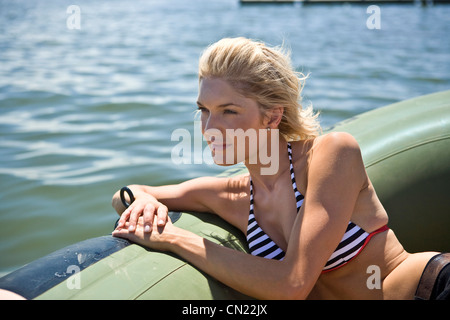 Giovane donna rilassante in gommone Foto Stock