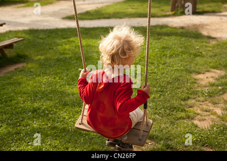 Giovane ragazzo su swing Foto Stock