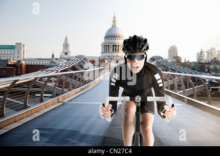 Ciclista ciclismo su Millennium Bridge di Londra, Inghilterra Foto Stock