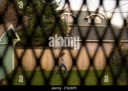 Vista attraverso la finestra Schermata di donna praticare il karate in giardino Foto Stock