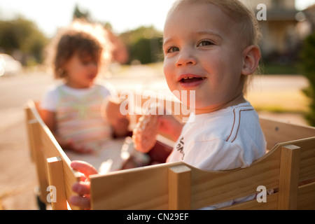 Due bambini seduti nel carro in legno Foto Stock