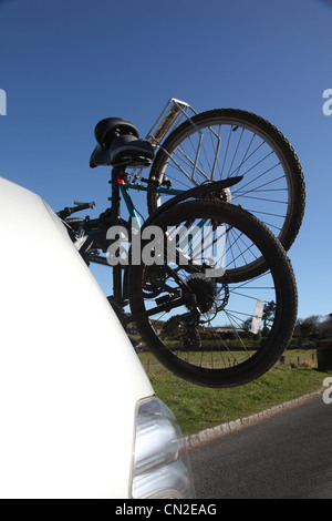 Due moto montato sul retro di un argento car guida attraverso una posizione rurale. Foto Stock